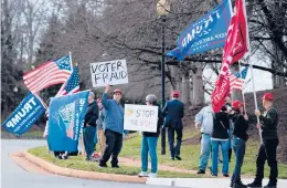  ?? BRENDAN SMIALOWSKI/GETTY-AFP ?? Supporters of President Donald Trump gather outside the Trump National Golf Club as the president plays golf Sunday in Sterling, Virginia.