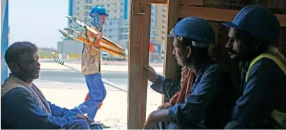  ?? Photo by Shihab ?? Workers sit under a shade during their break at a constructi­on site in Dubai on Wednesday. The midday break rule that comes into effect from today makes it mandatory for employers to give a break for workers from 12.30pm to 3pm. —