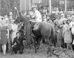  ?? SEAN M. HAFFEY/GETTY IMAGES ?? Jockey Mike Smith beams in the winner’s circle atop Justify after winning the Kentucky Derby Saturday. At 52, Smith became the second-oldest jockey to win the race.