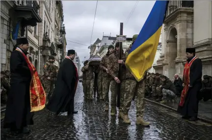  ?? AP PHOTO/PETROS GIANNAKOUR­IS ?? Soldiers carry the coffin of soldier Yurii Bulharu during a funeral ceremony outside the Holy Apostles Peter and Paul Church in Lviv, western Ukraine, on Saturday, Feb. 25, 2023. Bulharu died on Feb. 17in east Ukraine.