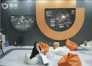  ?? REUTERS ?? A visitor sits at Didi Chuxing's booth during an internet expo in Beijing.