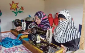  ?? — AFP ?? RAWALAKOT, Pakistan: In this photograph taken on November 21, 2016, Pakistani Kashmiri girls stitching cloth during their class in the women’s market on the outskirts of the town of Rawalakot, in Pakistani-administer­ed Kashmir.