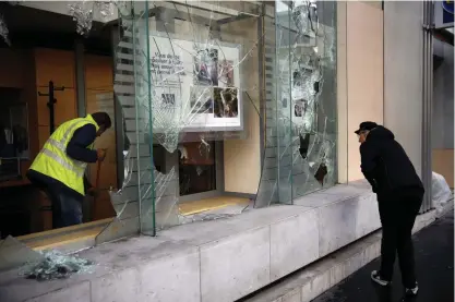  ?? FOTO: TT-AP/CHRISTOPHE ENA ?? En man städar bort krossat glas inne på en bank i Paris.