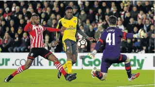  ?? Picture: REUTERS ?? CLASS ACT: Arsenal’s Danny Welbeck, centre, scores the first of his two goals against Southampto­n at St Mary's Stadium last night. The Gunners won 5-0, Theo Walcott scoring a hat-trick