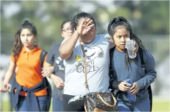  ?? DAMIAN DOVARGANES/THE ASSOCIATED PRESS ?? People pick up students after a shooting at the Salvador B. Castro Middle School near downtown Los Angeles, Calif., on Thursday. A 15-year-old boy was shot in the head and a 15-year old girl was shot in the wrist.