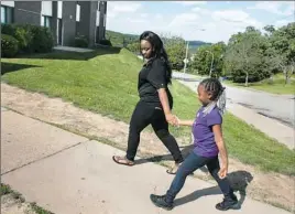  ?? Stephanie Strasburg/Post-Gazette photos ?? Shymari Freeman, 19, walks her daughter, Journey, to their apartment in Crafton Heights on Tuesday after a dentist's appointmen­t. She is on track to graduate from Brashear High School in June and plans to study nursing.