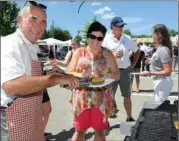  ??  ?? Craig Garries, left, director with the Greater Westside Board of Trade, serves a burger to Julie Pringle, with Snap Commercial Photograph­y. In the background, Alex Draper, with the Greater Westside Board of Trade, chats with Teri Kanner, with the...