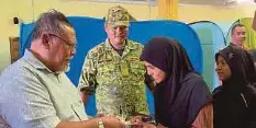  ?? ?? AMINOLHUDA menyantuni mangsa banjir di PPS, SMK Seri Gading.