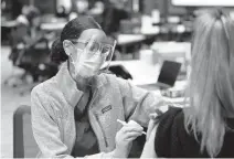  ?? STEPHEN M. KATZ /STAFF FILE ?? EVMS medical student Faven Russom gives fellow student Marie Yrastorza the Pfizer COVID-19 vaccine at EVMS on Feb. 12. Upwards of 500,000 doses are coming to Hampton Roads.