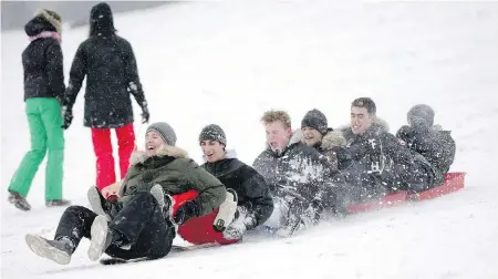  ?? YUI MOK/PA VIA AP ?? People ride sleds in the snow at Primrose Hill in London on Friday as “the Beast from the East” cold front gripped Europe.