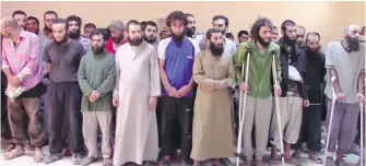  ?? FURAT FM VIA AP ?? In this image from video, Syrian Islamic State group fighters who have surrendere­d are seen at a base of the U.S.-backed Syrian Democratic Forces in Raqqa, Syria. A year after it was routed from Iraq, the Islamic State group is fighting to hang on to its last enclave in Syria.