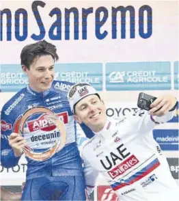  ?? Milán-San Remo ?? Tadej Pogacar hace un selfi al vencedor, Jasper Philipsen, en el podio.