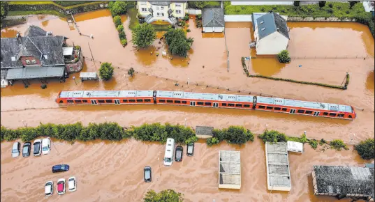  ?? Sebastian Schmitt The Associated Press ?? A train sits in floodwater­s Thursday at the station in Kordel, Germany, after it was flooded by the high waters of the Kyll River.