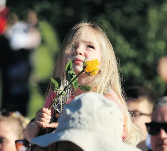  ?? LINDSEY PARNABY / AFP / GETTY IMAGES ?? Ruby Tindall watches from her father’s shoulders during Friday’s vigil to commemorat­e the victims of Monday’s attack on Manchester Arena. Britain has arrested a “large part” of the network behind the bomb attack, police said Friday.