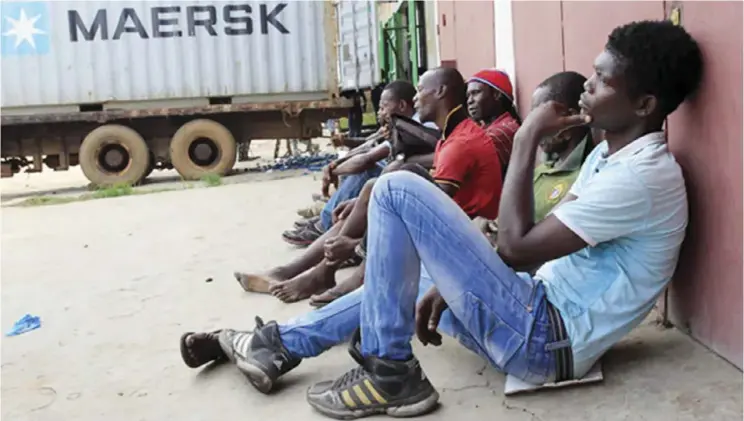  ??  ?? Unemployed Liberian young men seeking daily jobs at the industrial district of Bushrod Island, Monrovia, Liberia.