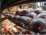  ?? (AP/Keith Srakocic) ?? Rows of fresh meat are seen through the display coolers as a woman enters the retail section of the Wight’s Meat Packing facility in Fombell, Pa.