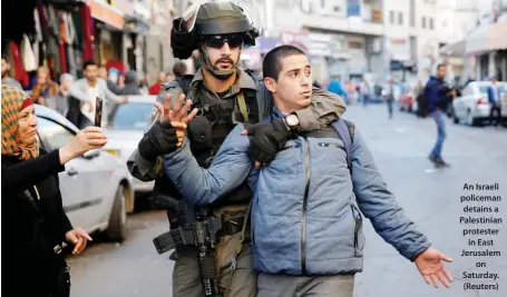  ??  ?? An Israeli policeman detains a Palestinia­n protester in East Jerusalem on Saturday. (Reuters)