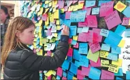  ?? PHILIP O'CONNOR / REUTERS ?? A girl writes a message on the memorial wall following Friday’s attack in Stockholm, Sweden, on Monday.