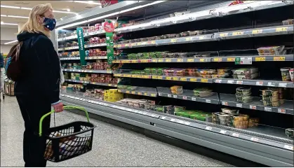  ?? ?? MIND THE GAPS: A disappoint­ed shopper is confronted with depleted shelves at a Morrisons supermarke­t yesterday
