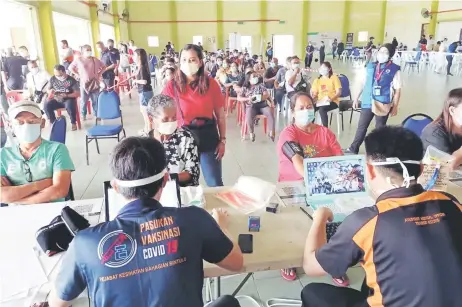  ??  ?? Vaccine recipients being screened by medical personnel at Tatau Sports Hall prior to receiving their jabs on Saturday.