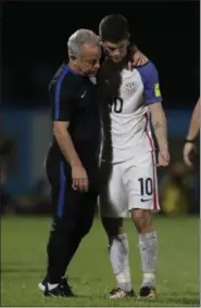  ?? REBECCA BLACKWELL — THE ASSOCIATED PRESS ?? Christian Pulisic, right, is comforted by a member of the team staff after the United States lost to Trinidad and Tobago in a World Cup qualifying match on Oct. 10 at Ato Boldon Stadium in Couva, Trinidad.