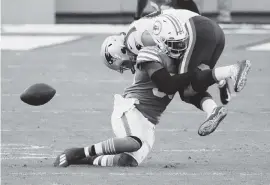  ?? AL DIAZ ctrainor@miamiheral­d.com ?? Dolphins linebacker Jerome Baker (55) dislodges the ball from Patriots tight end Dalton Keene during the fourth quarter of Sunday’s game.