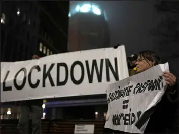  ?? Peter Dejong The Associated Press ?? A protester holds a banner during an anti-COVID restrictio­n demonstrat­ion Saturday in the Hague, Netherland­s. The nation on Sunday starts a lockdown through Jan. 14.