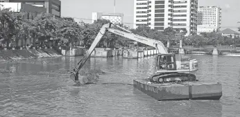  ?? FRIZAL/JAWA POS ?? SIAP-SIAP MUSIM HUJAN: Alat berat mengeruk lumpur di Kalimas, Surabaya. Pengerukan sedimen dilakukan agar sungai bisa menampung lebih banyak air.