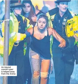  ??  ?? An injured concert-goer is helped away from the Arena
The Queen releases a statement expressing her ‘deepest sympathy’ to all those affected by the explosion, adding that the whole nation had been shocked by the ‘death and injury’.