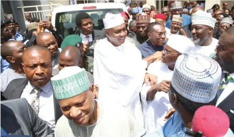  ??  ?? Senate President Bukola Saraki (middle) acknowledg­es cheers from his friends and supporters after the Code of Conduct Tribunal (CCT) dismissed the false asset declaratio­n charge against him in Abuja on Wednesday.