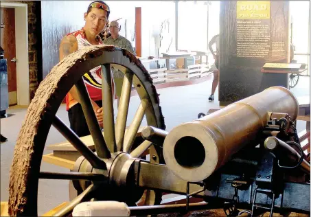  ??  ?? Tahlequah, Okla. resident Ellic Miller looks at a cannon exhibit at Pea Ridge National Military Park.