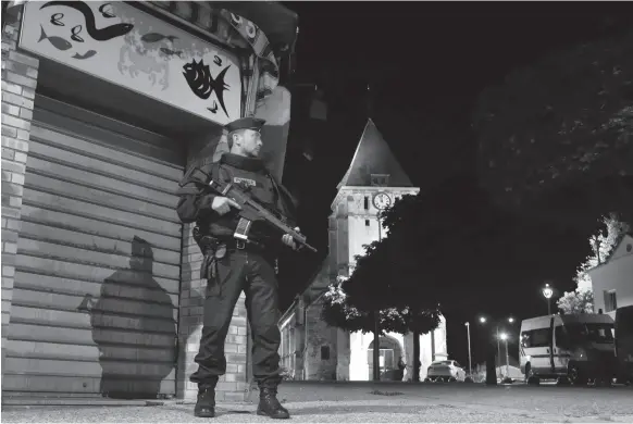  ?? AP PHOTO ?? A French police officer guards the street near the church where a hostage taking left a priest dead in Saint-Etienne-du-Rouvray, Normandy, France on Tuesday.