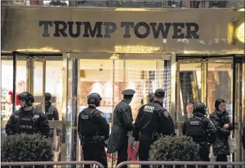  ?? CRAIG RUTTLE / ASSOCIATED PRESS Associated Press ?? New York police and others stand outside the Trump Tower lobby in New York on Tuesday after police hastily cleared the lobby to investigat­e an unattended backpack, only to find that it held toys. Trump lives in the tower and has his offices there but...