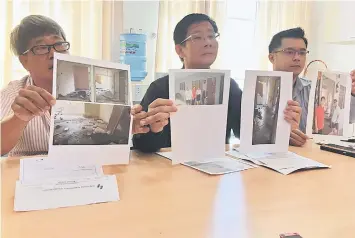  ??  ?? Tan (centre) shows photos of the abandoned flats together with Ng (left) and Democratic Action Party Socialist Youth Stampin chief Bong Kuet Vui.