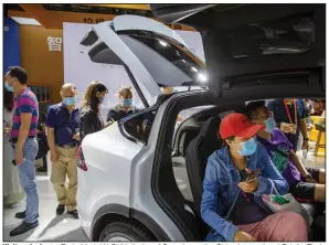  ?? (AP/Mark Schiefelbe­in) ?? Visitors look at a Tesla Model X SUV displayed Saturday at the China Internatio­nal Fair for Trade in Services in Beijing.