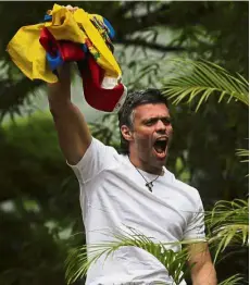  ??  ?? Lopez holding up a Venezuelan national flag while greeting supporters outside his home in Caracas after his release from prison. — AP Symbol of resistance: