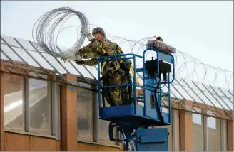  ?? MIKE CHRISTY/ARIZONA DAILY STAR VIA AP ?? IN THIS NOV. 7 PHOTO (AT LEFT), U.S. Army troops with the 16th Military Police Brigade install concertina wire atop the U.S.-Mexico border near the Morley pedestrian gate just east of the DeConcini Port of Entry in Nogales, Ariz.