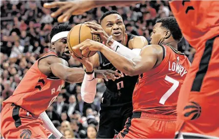  ?? Nathan Denette / Associated Press ?? Russell Westbrook (centro) recibe una falta mientras es marcado por Terence Davis (izq.) y Kyle Lowry durante la victoria de los Rockets el jueves 5 de diciembre ante los Raptors en Toronto, Canadá.