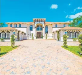  ?? MILES GOLDSTEIN REAL ESTATE/COURTESY ?? The 11,500-square-foot contempora­ry mansion sits on two acres of lush greenery located directly across from the Adios Golf and Country Club.