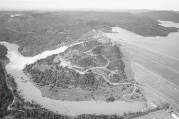  ??  ?? Oroville lake, the emergency spillway, the damaged main spillway, and the earthen Oroville Dam are seen from the air in Oroville, California. — AFP photo