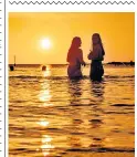  ??  ?? Swimmers enjoy a golden sunrise at Cullercoat­s Bay, North Tyneside, yesterday