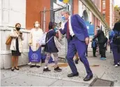  ?? JOHN MINCHILLO AP FILE ?? New York Mayor Bill de Blasio (center right) greets students as they arrive for in-person classes in September in the Manhattan borough of New York.