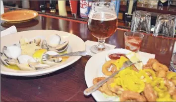  ??  ?? Calamari and oysters at the Blue Water Grill in Skaneatele­s.