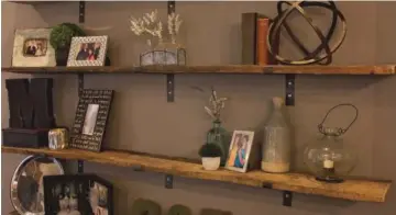  ??  ?? The floating shelves in the living room are made of repurposed wood from the bed of a 1918 hauling truck.The brackets were custom made by Ryan’s grandparen­ts.