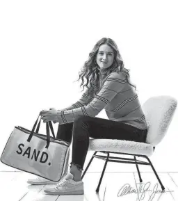  ?? COURTESY OF ALLISON TYLER JONES ?? Isabella DiGiovann holds one of Sand Custom Designs’ tote bags in this promotiona­l photo. She started the company along with her friend, Connor Nannen.