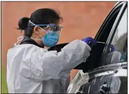  ?? (AP/Seth Wenig) ?? Medical workers conduct coronaviru­s testing Wednesday at a drive-thru site in Lawrence, N.Y. New York’s hospitaliz­ation count exceeded 900 this week for the first time since May, and New Jersey’s hit 844, the highest since July.