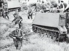  ?? Photo: Australian War Memorial ?? Troops of 1APC Squadron and infantry sweep the area the day after the Battle of Long Tan in then Phuoc Tuy province of South Vietnam, now Ba Ria-Vung Tau province of Vietnam.