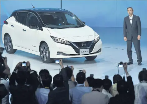  ?? AFP ?? Hiroto Saikawa, CEO of Nissan Motor Co Ltd, stands next to the company’s new Leaf electric vehicle during its world premiere in Makuhari, Chiba prefecture yesterday.