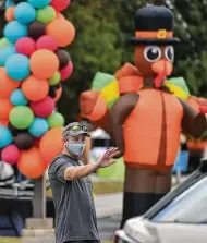  ??  ?? Rich Miglore directs traffic during the event, at which 50 employees, their families and board members volunteere­d at stations around the Firstmark parking lot.