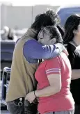  ?? J Pat Carter / Getty Images ?? Family members comfort one another after a shooting at a Walmart parking lot on Monday left three people dead in Duncan, Okla.